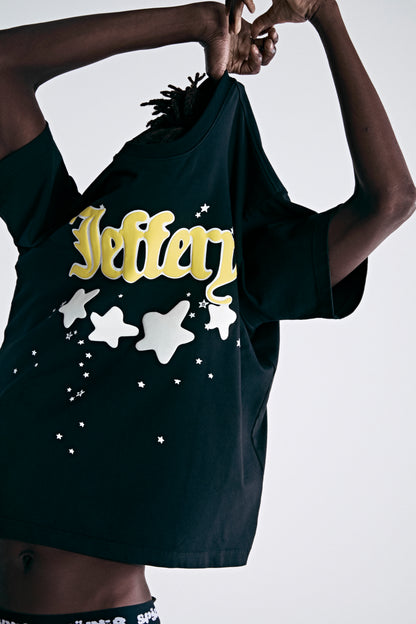 Black 100% cotton heavyweight tee with yellow "Jeffery" script and white puff print stars.