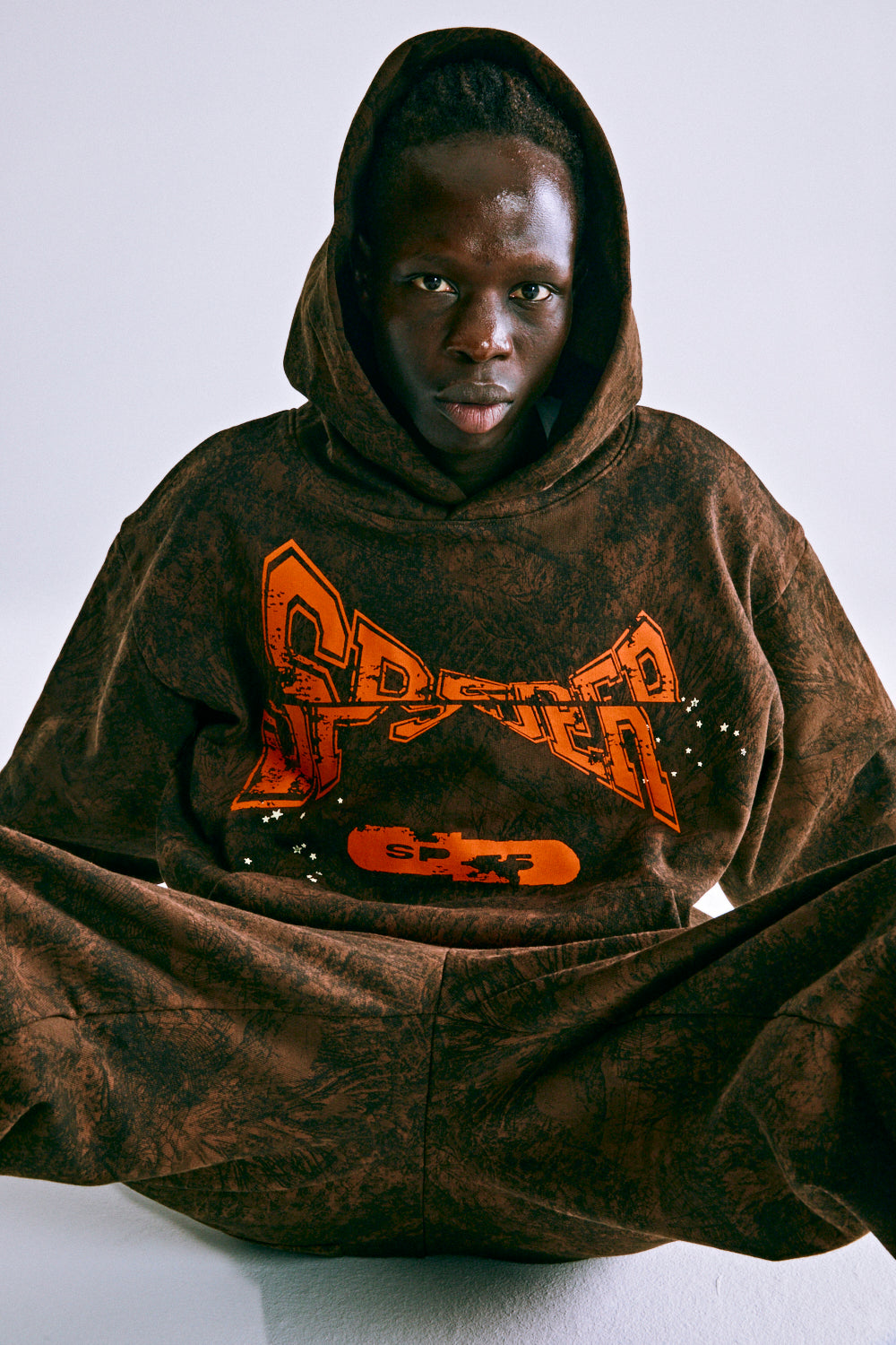 Brown 13oz cotton fleece T&F TREE CAMO HOODIE with orange SP5DER chest print.