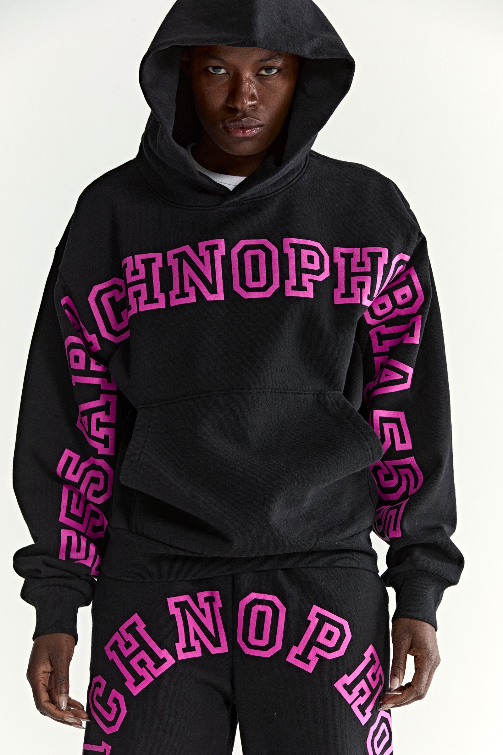 Black 13oz cotton fleece ARACH HOODIE with bold pink puff print text on chest and arms, kangaroo pocket.