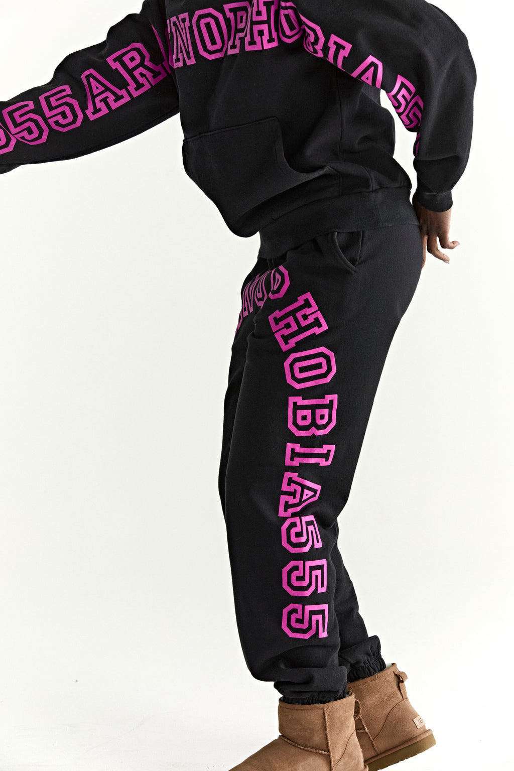 Black ARACH hoodie and sweatpants with bold pink puff print text, kangaroo pocket, and rib knit cuffs.