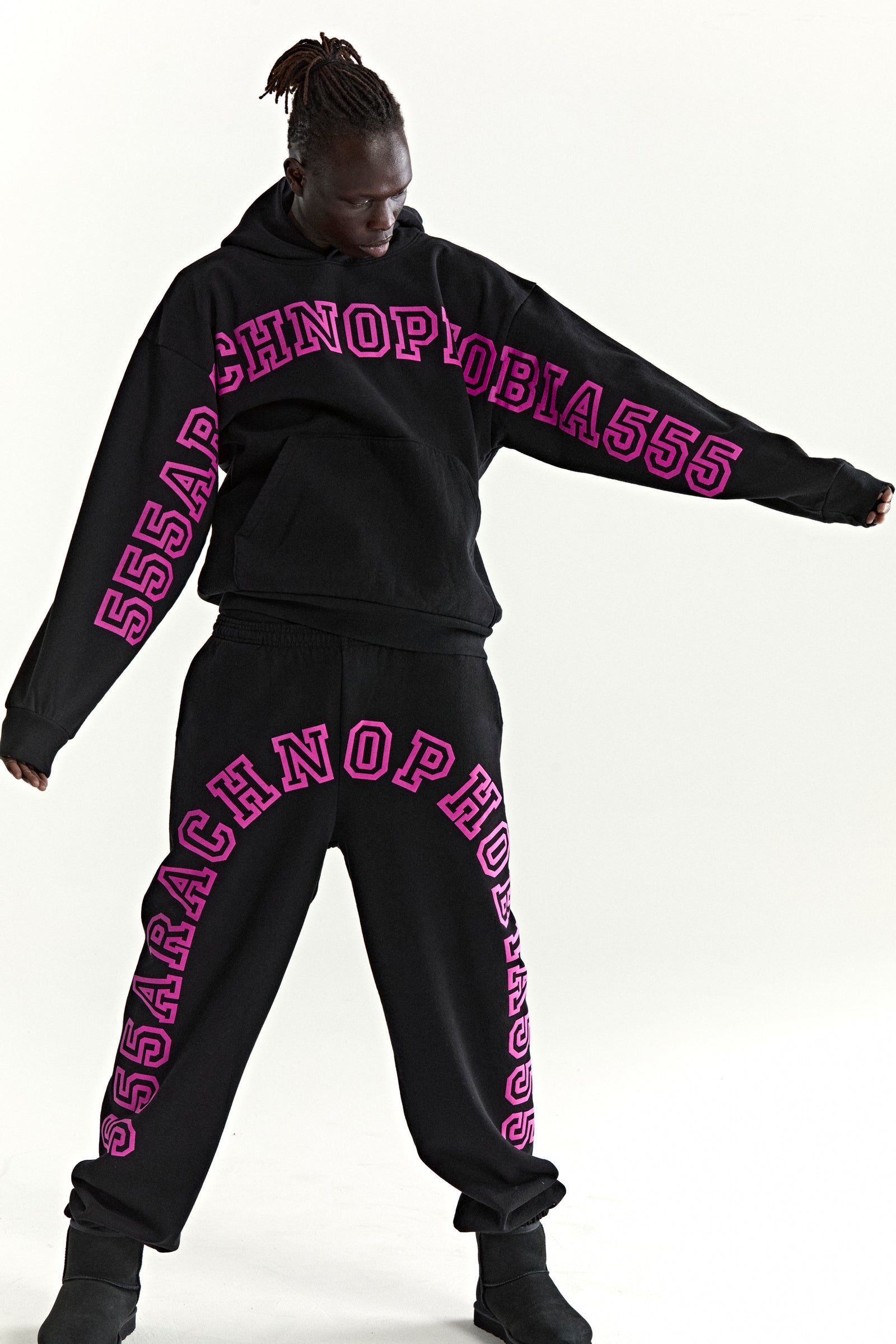 Black ARACH HOODIE and sweatpants with pink "ARACHNOPHOBIA555" text print.