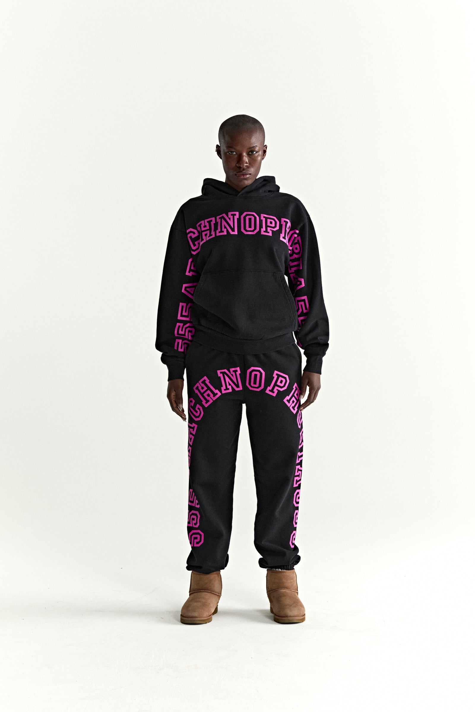 Black ARACH HOODIE and sweatpants set with bold pink puff print text, kangaroo pocket, and rib knit details.