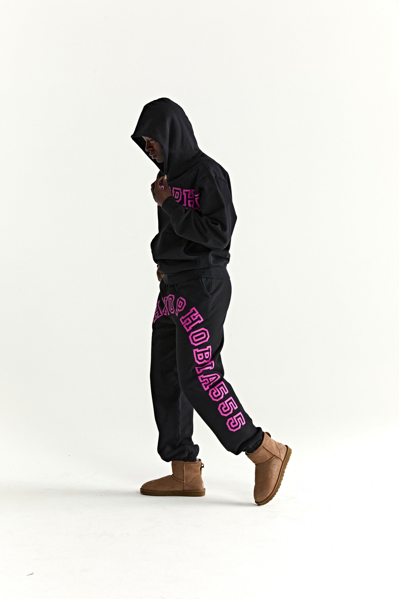 Black ARACH HOODIE and sweatpants with pink text print, kangaroo pocket, rib knit cuffs, and hem.