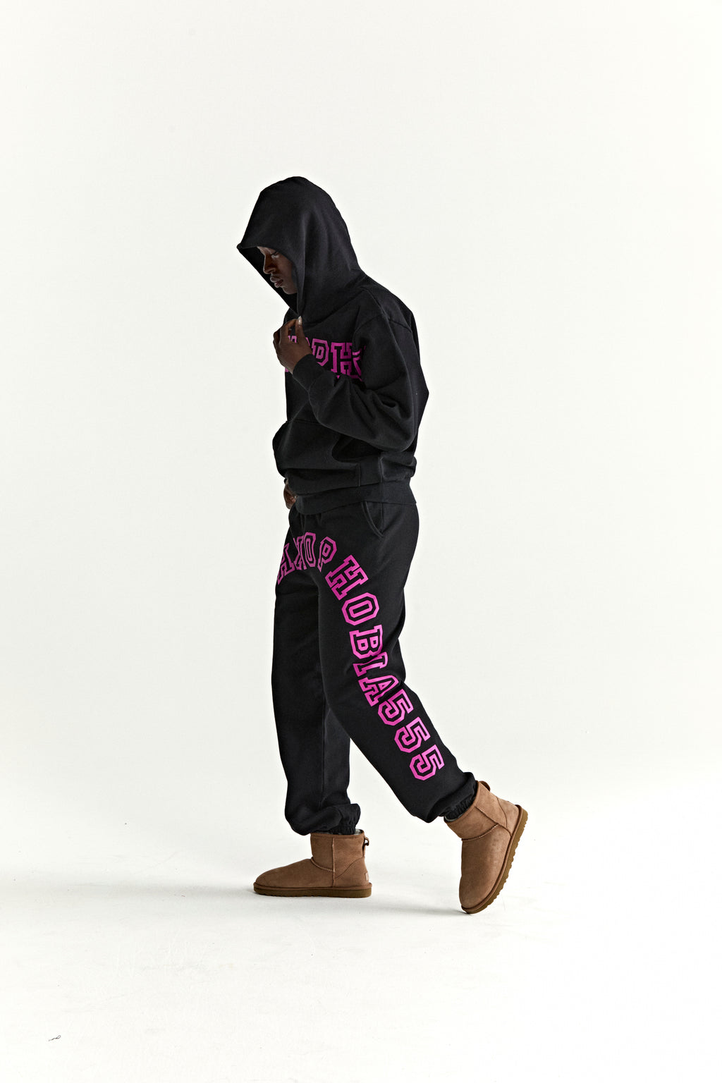 Black ARACH HOODIE and sweatpants with pink text print, kangaroo pocket, rib knit cuffs, and hem.