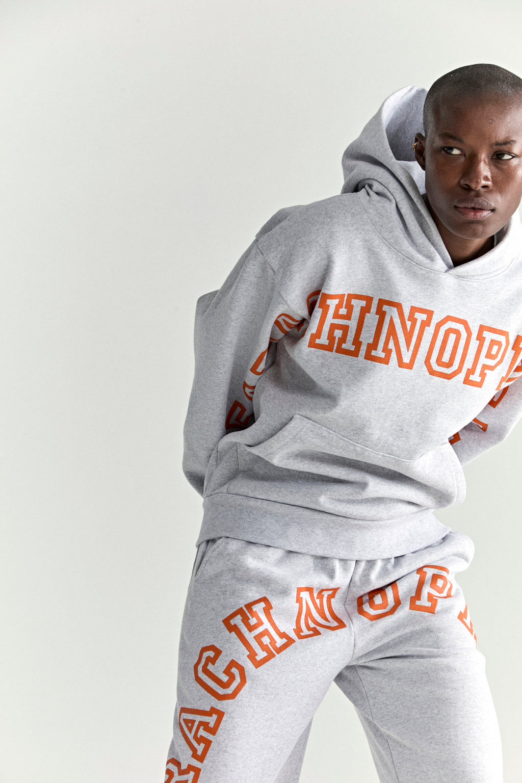 Gray 13oz cotton fleece ARACH HOODIE and sweatpants with orange puff print text.