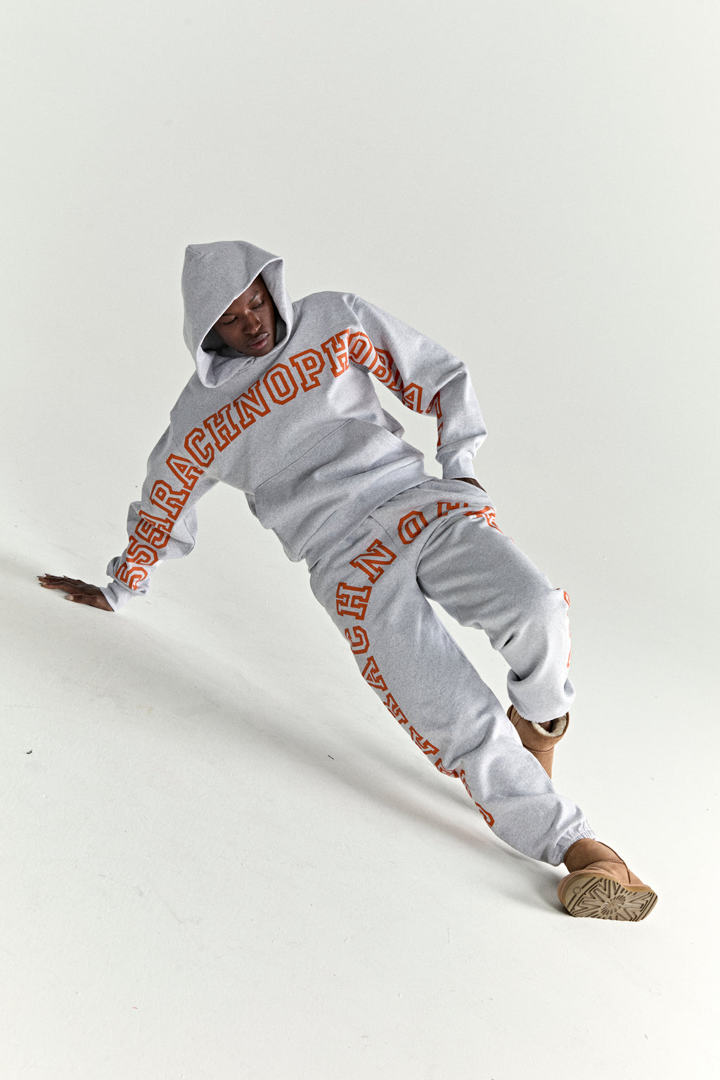 Gray 13oz cotton fleece ARACH hoodie and sweatpants with orange puff print text.