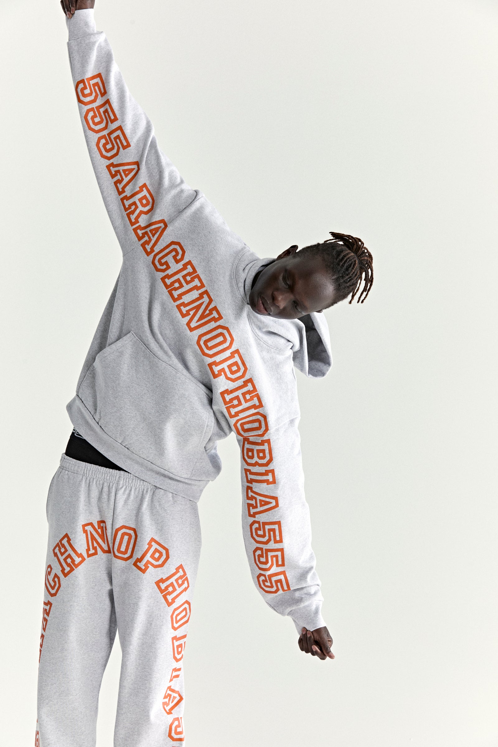 Grey cotton fleece hoodie and sweatpants with orange "ARACHNOPHOBIA" text print.
