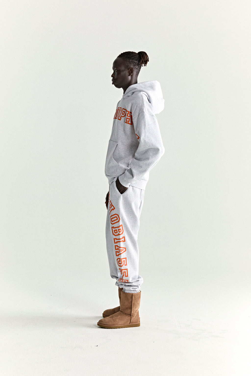 Gray 13oz cotton fleece hoodie and sweatpants with orange puff print text, kangaroo pocket, and rib knit details.