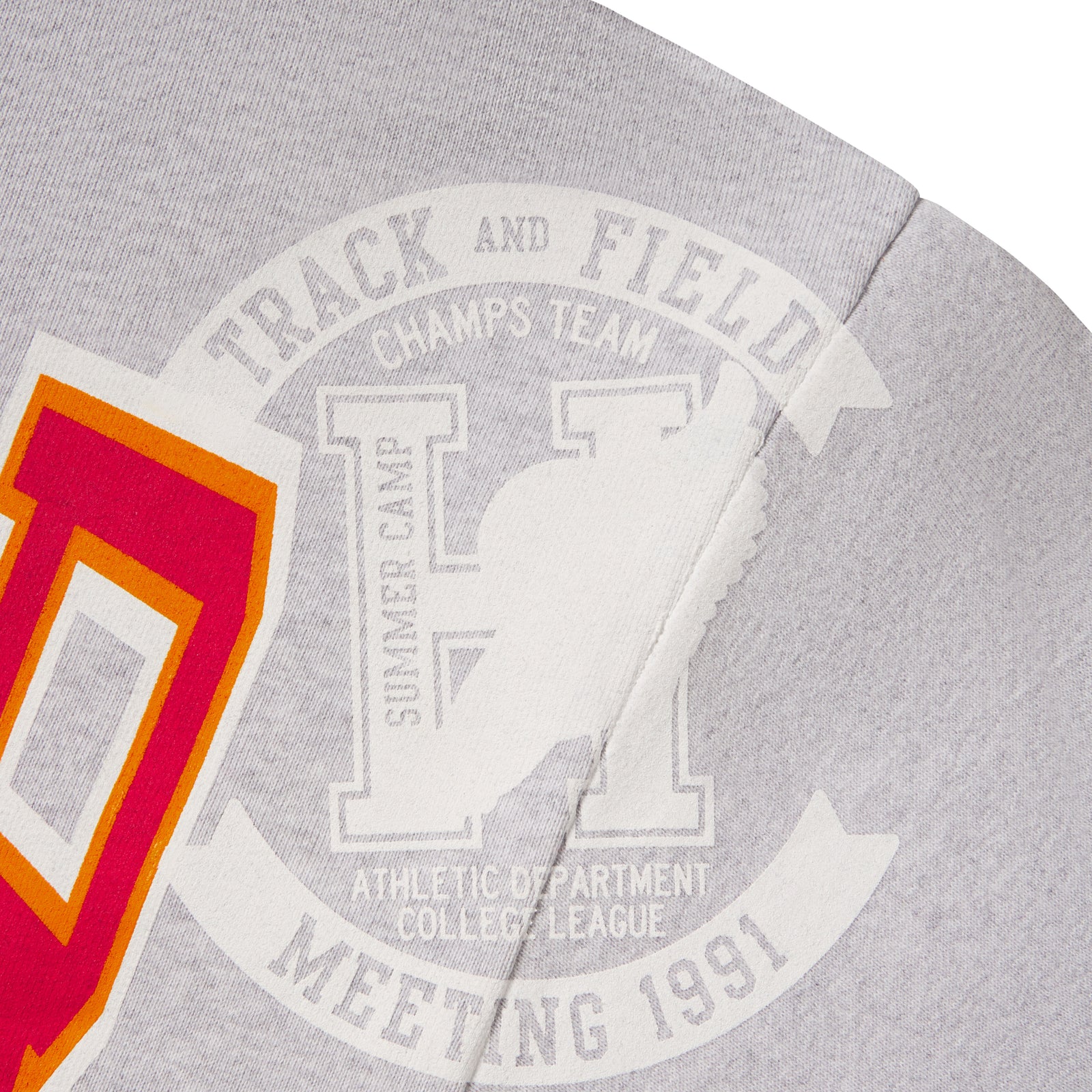Grey 13oz cotton fleece zip hoodie featuring a varsity-inspired Track and Field graphic print in white, orange, and red.