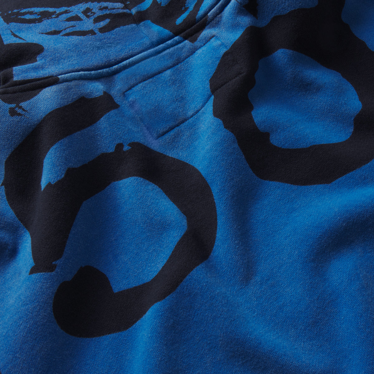 Blue 13oz cotton fleece zip hoodie featuring a bold black graphic print across the fabric.