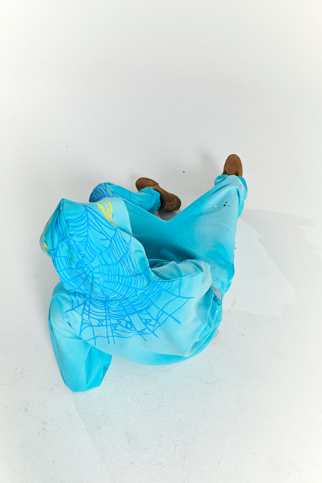 Aqua blue heavy web hoodie with spiderweb print on back, scattered stars on front, and kangaroo pocket.