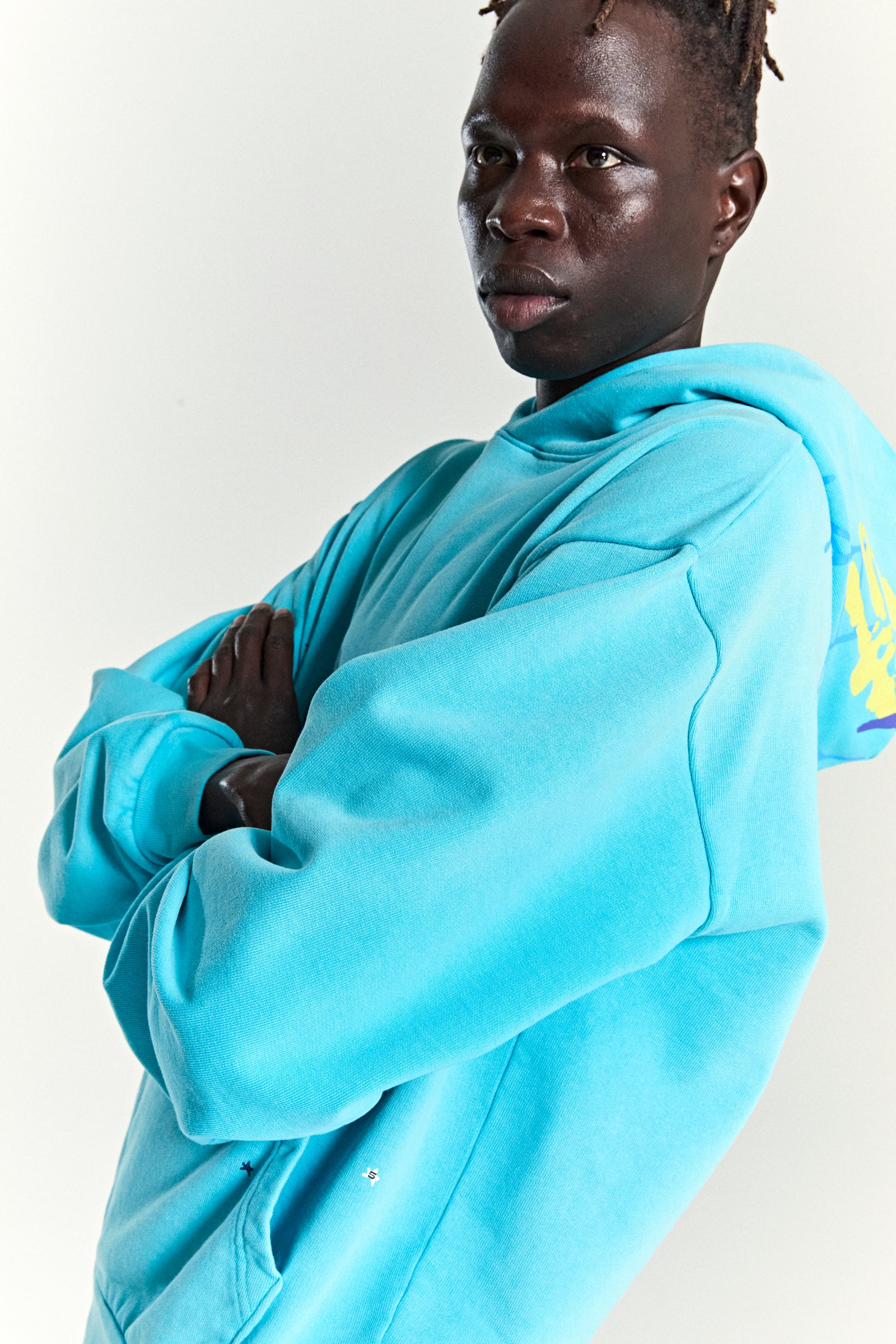 Turquoise heavy web hoodie with star print, kangaroo pocket, and web print on back hood.