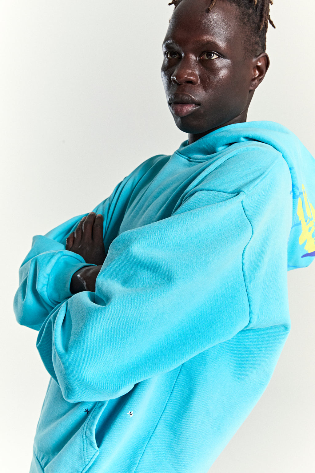 Turquoise heavy web hoodie with star print, kangaroo pocket, and web print on back hood.