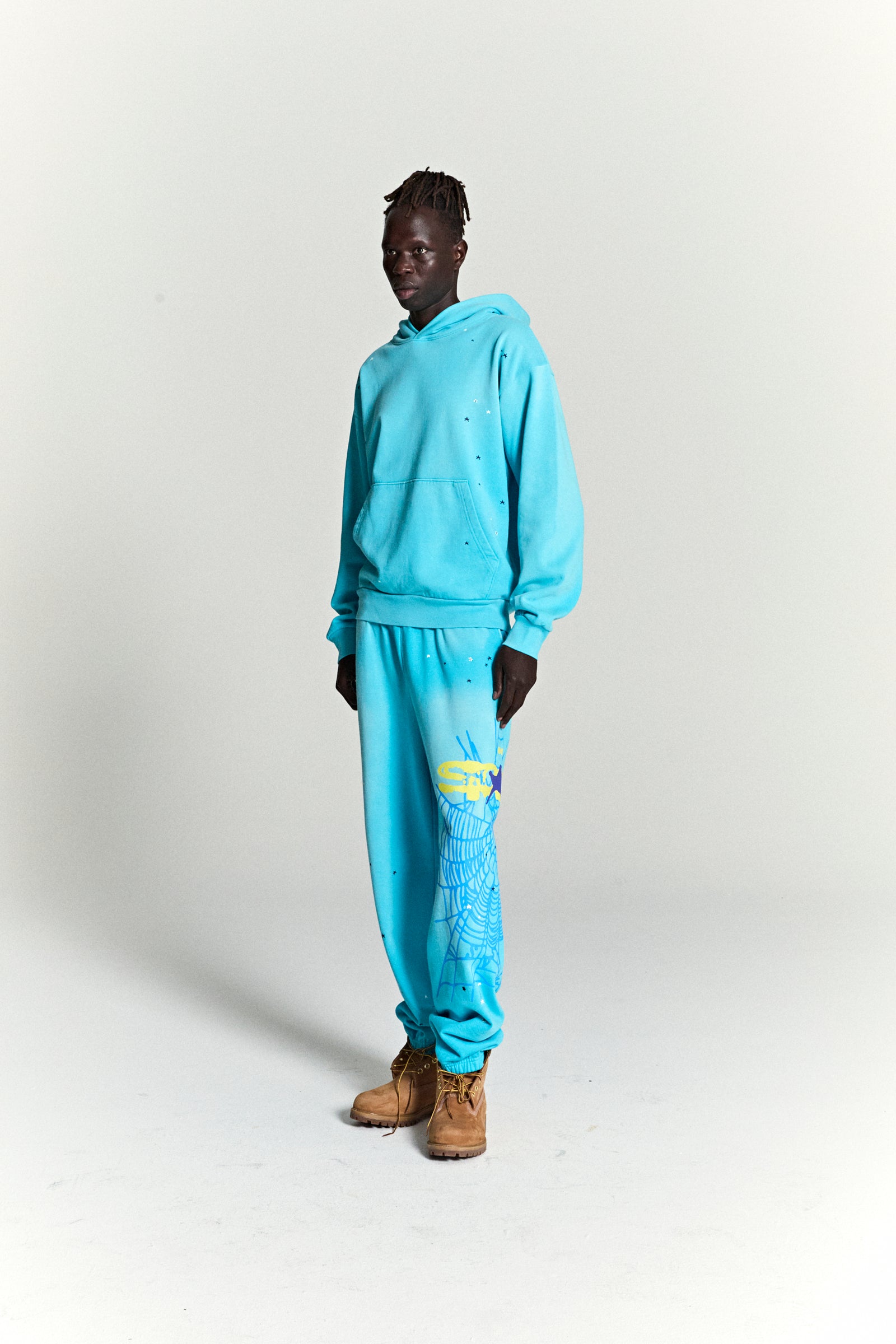 Aqua blue HEAVY WEB HOODIE and sweatpants set with scattered stars and a web print.