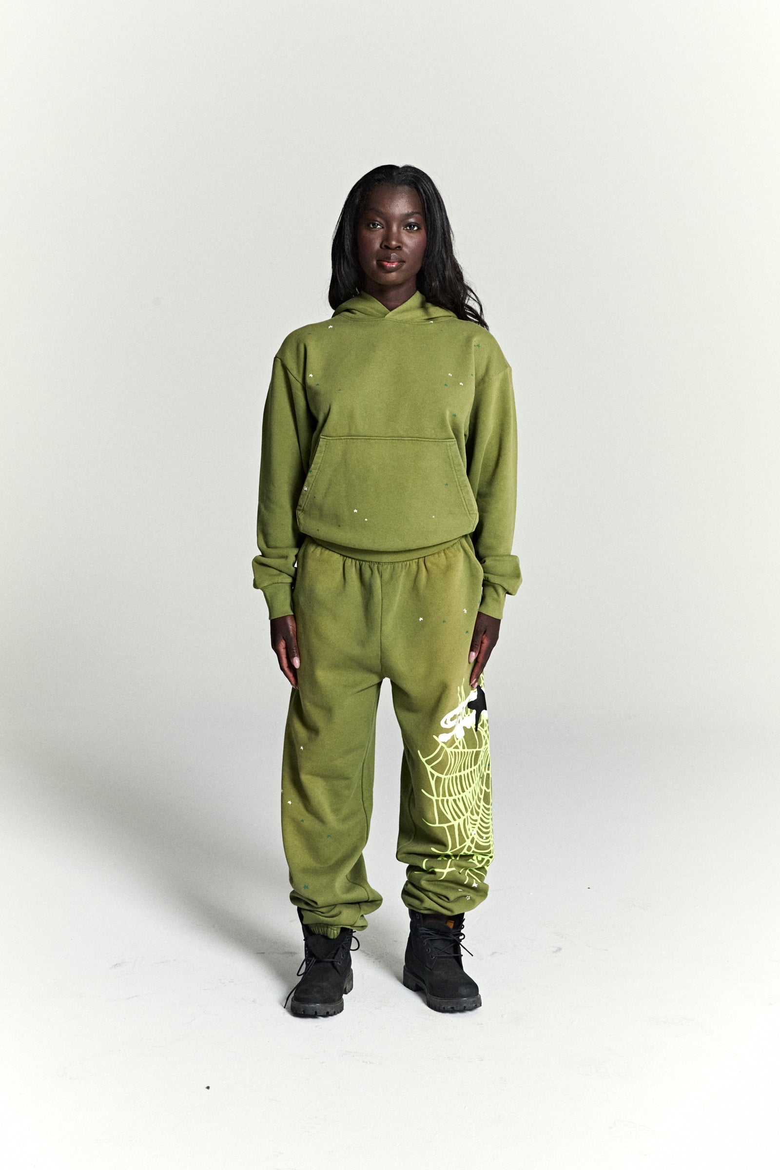 Olive green cotton fleece hoodie and sweatpants set with scattered star print and a large web print.