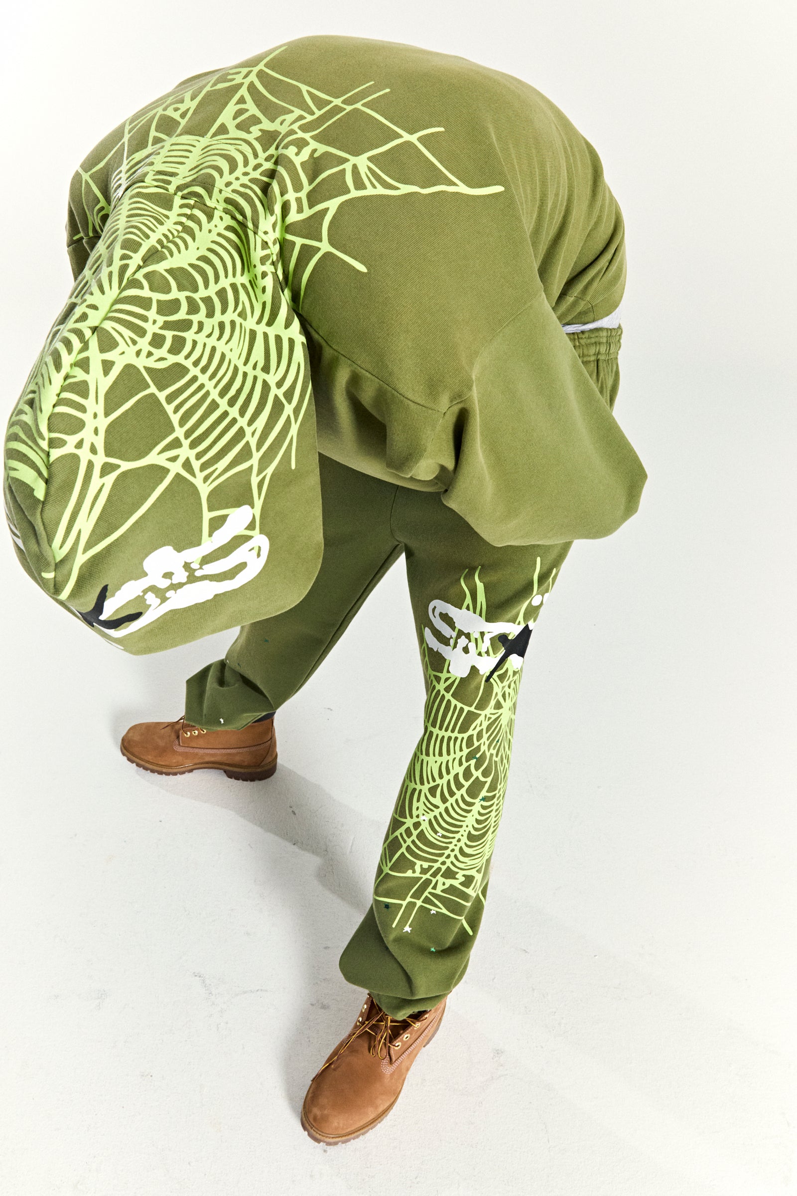 Olive green cotton fleece hoodie and sweatpants with neon green spider web and skull prints.