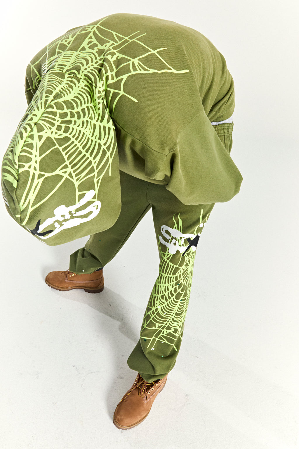 Olive green cotton fleece hoodie and sweatpants with neon green spider web and skull prints.
