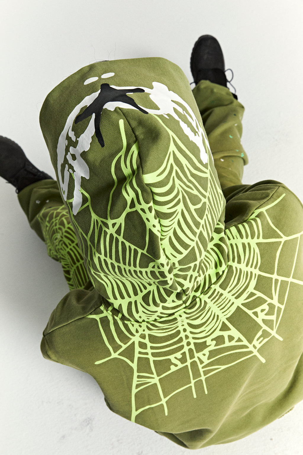 Olive green heavy web hoodie with neon green spiderweb print on back hood and shoulders.