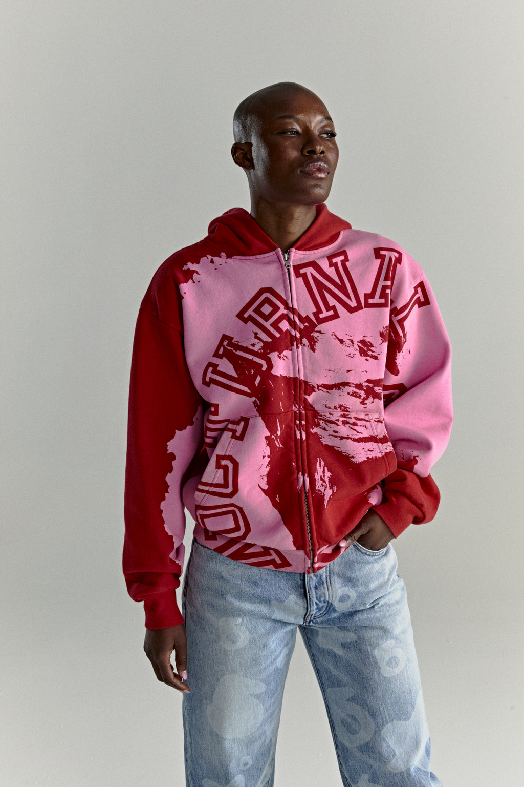 NOCTURNAL ZIP HOODIE: Color-blocked pink and red 13oz cotton fleece hoodie with varsity arch lettering.