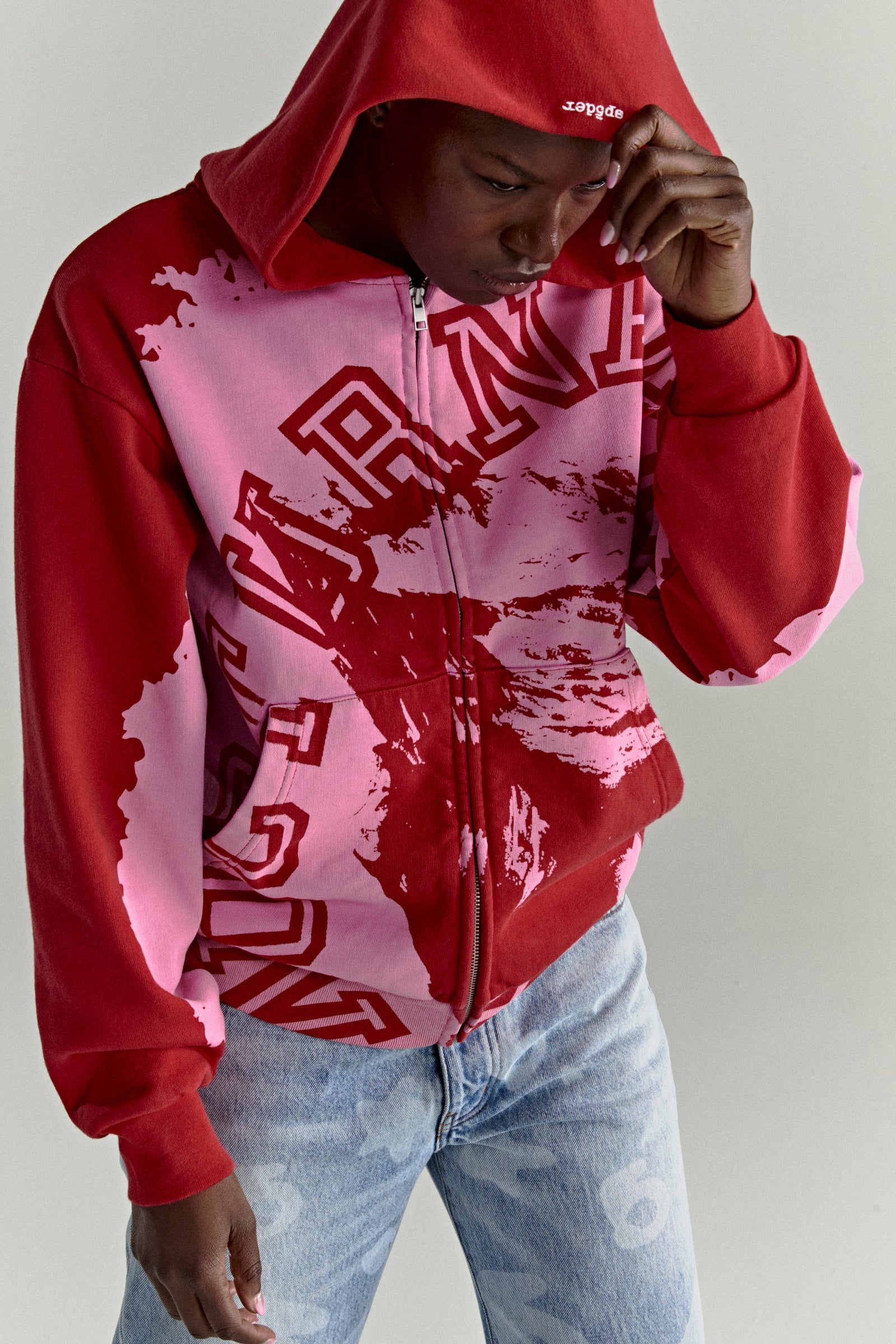 Red and pink color-blocked NOCTURNAL ZIP HOODIE with varsity lettering, embroidered hood logo, and split pockets.