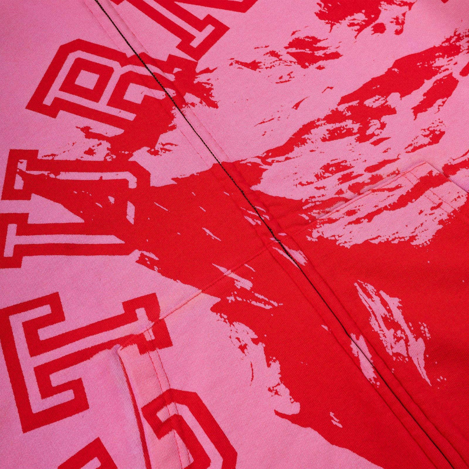 Pink cotton fleece zip hoodie with red varsity lettering and abstract red splatter design.
