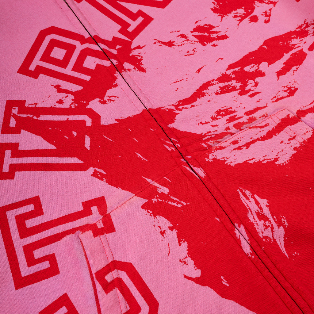 Pink cotton fleece zip hoodie with red varsity lettering and abstract red splatter design.