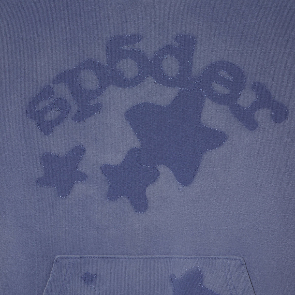 Close-up of a blue hooded sweatshirt with a tonal embroidered 'Spider' logo and star motif on the chest, plus a front kangaroo pocket.