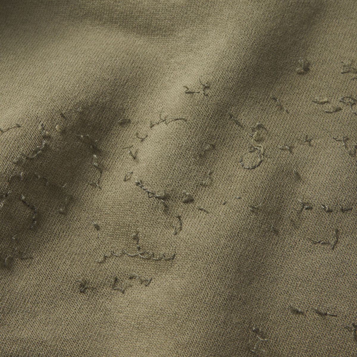 Close-up of olive green 13oz cotton fleece hoodie with distressed SP5DER graphic print and star design.
