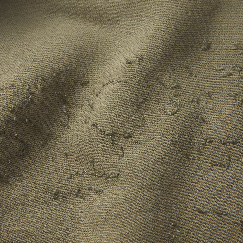 Close-up of olive green 13oz cotton fleece hoodie with distressed SP5DER graphic print and star design.