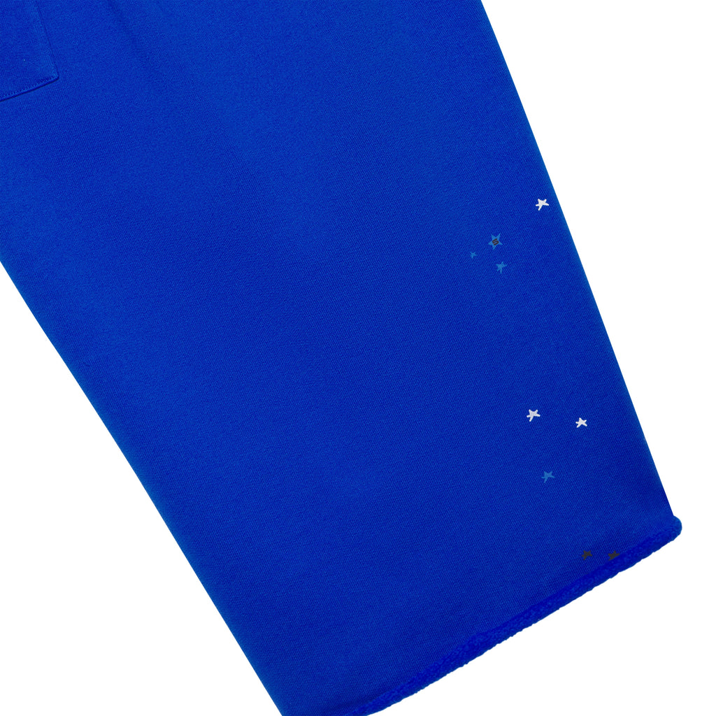 Royal blue brushed fleece long shorts with scattered star print and raw hem.