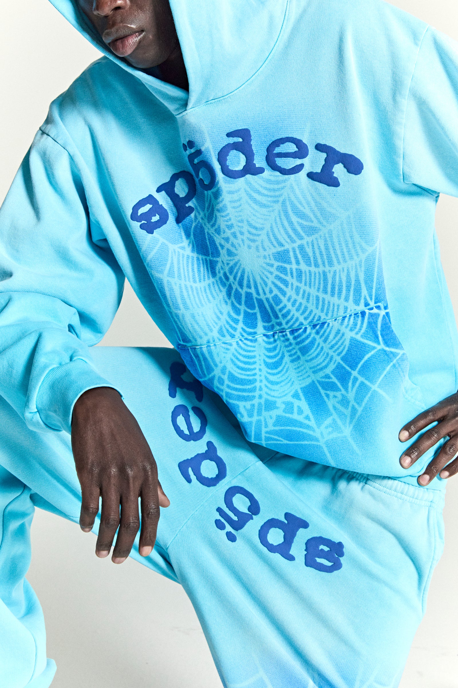 Light blue cotton fleece hoodie and sweatpants with blue "spider" text and spray web V2 print.