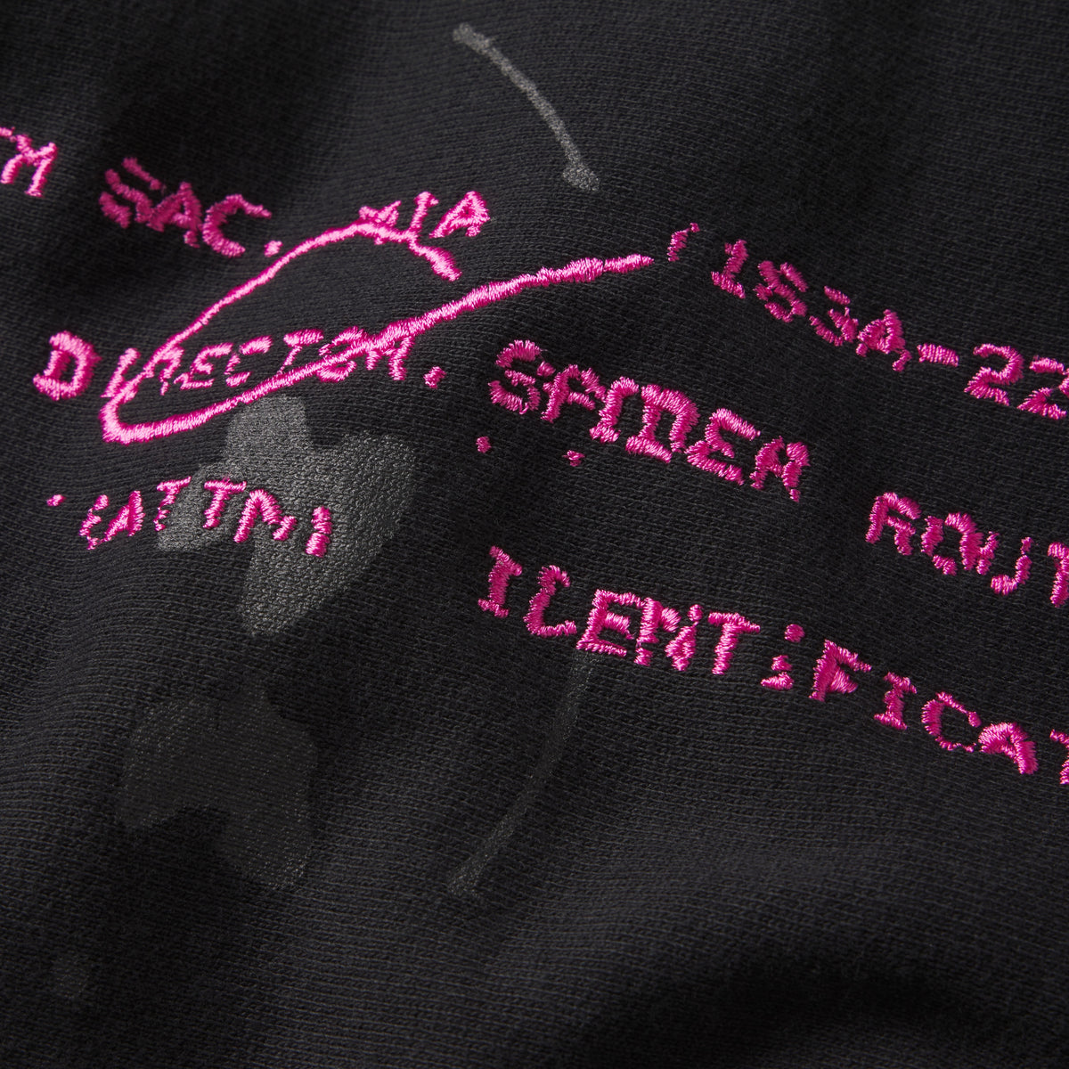 Black cotton fleece hoodie featuring pink embroidered graphic text and distressed abstract print detailing.