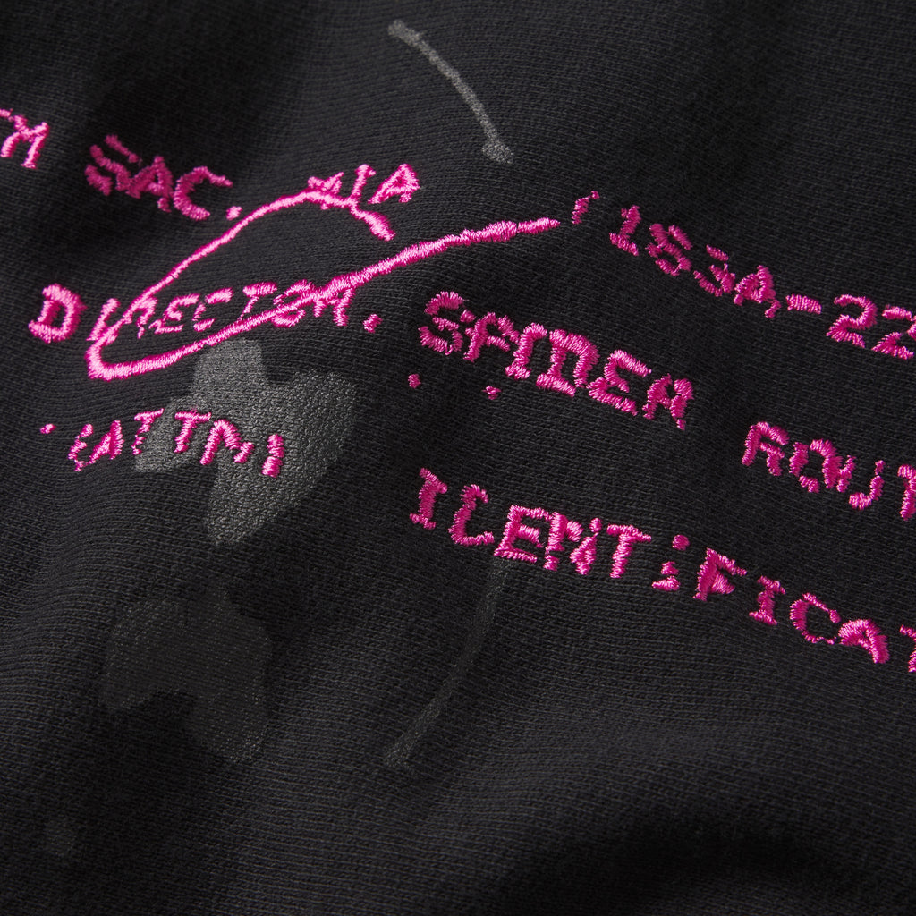 Black cotton fleece hoodie featuring pink embroidered graphic text and distressed abstract print detailing.