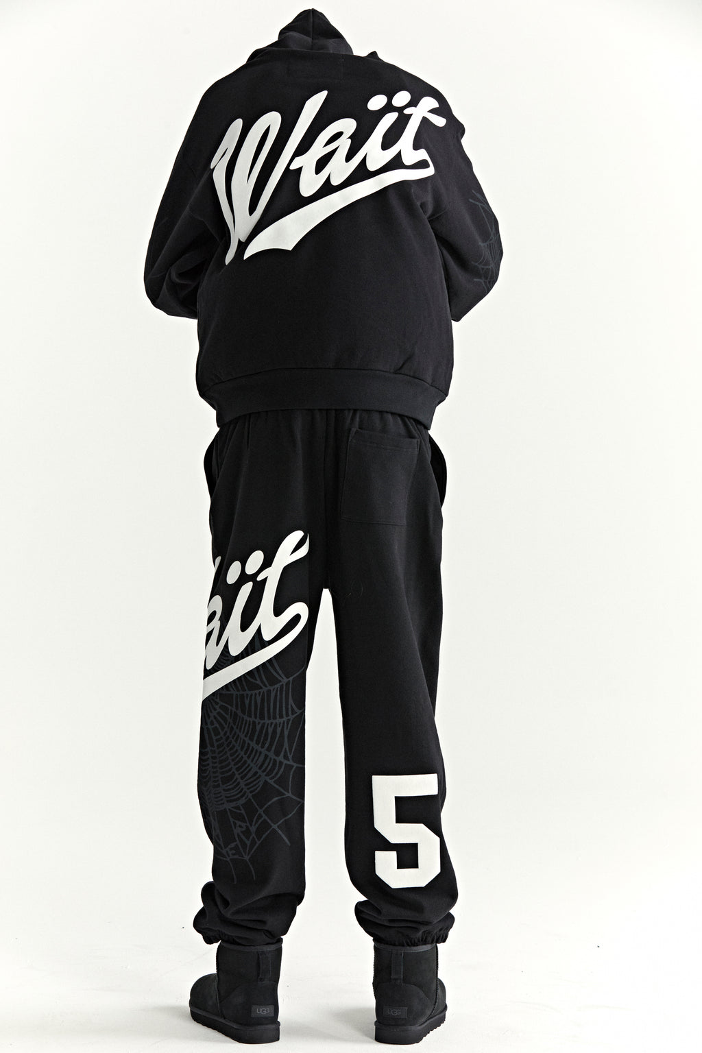 Black STADIUM HOODIE and sweatpants with "Wait" script, "5" graphic, and web detail.