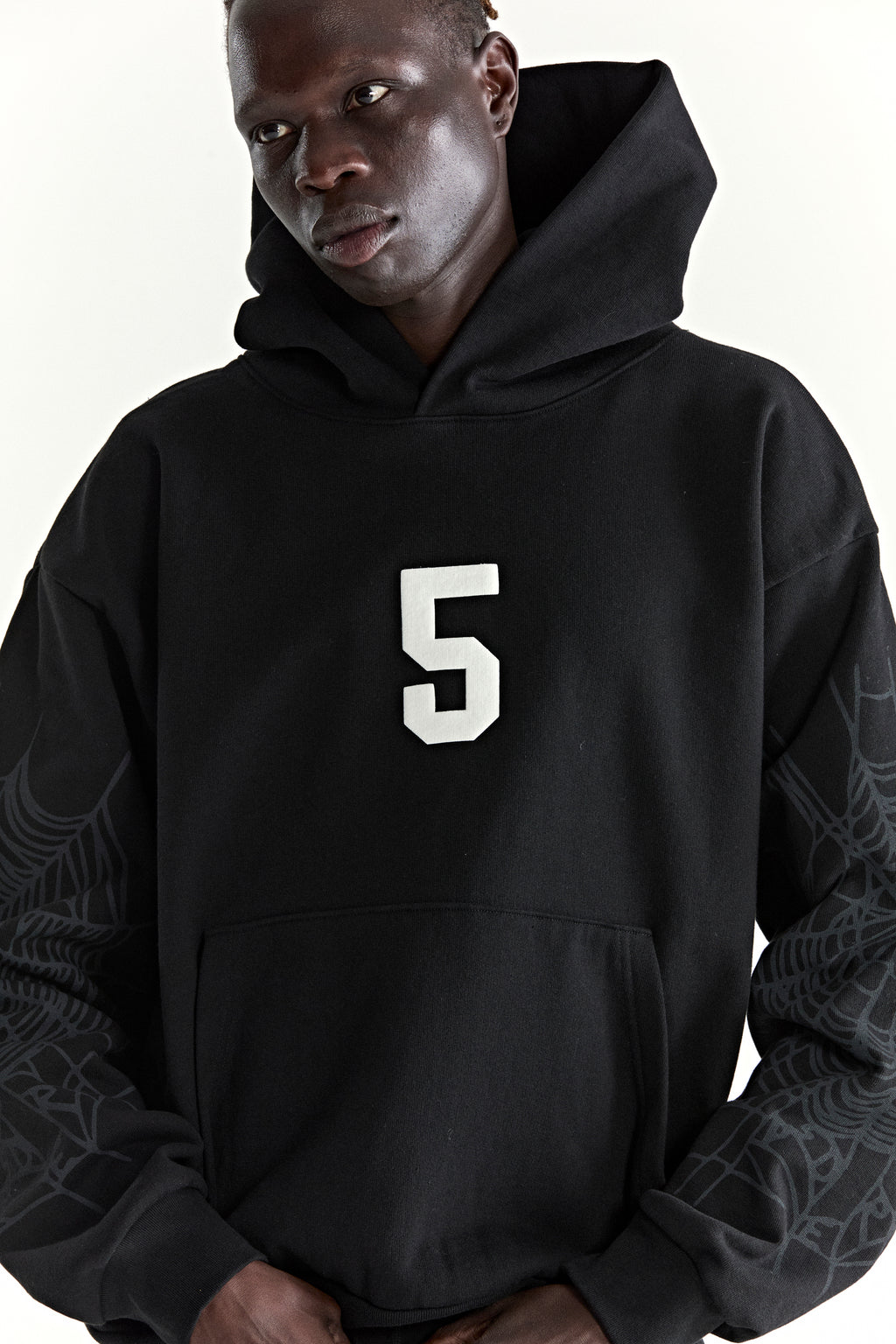 Black 13oz cotton fleece STADIUM HOODIE with white '5' puff print, web sleeves, and kangaroo pocket.