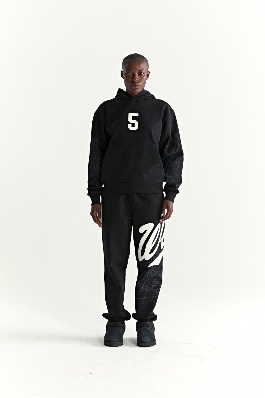 Black cotton fleece hoodie with white '5' graphic and web detail, matching sweatpants with 'Wait' script.