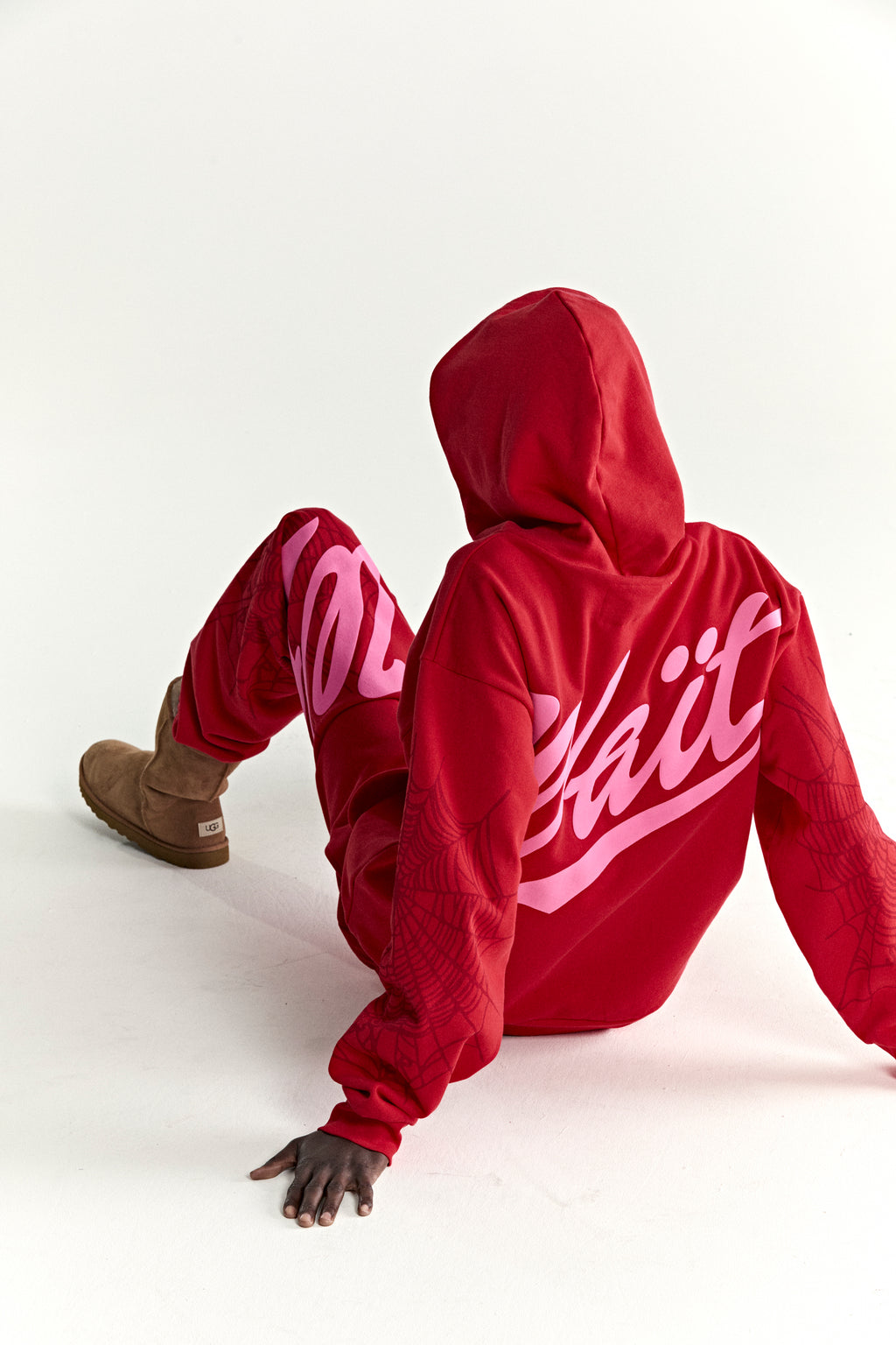 Red 100% cotton fleece hoodie with "Wait" script, web detail sleeves, and matching pants.