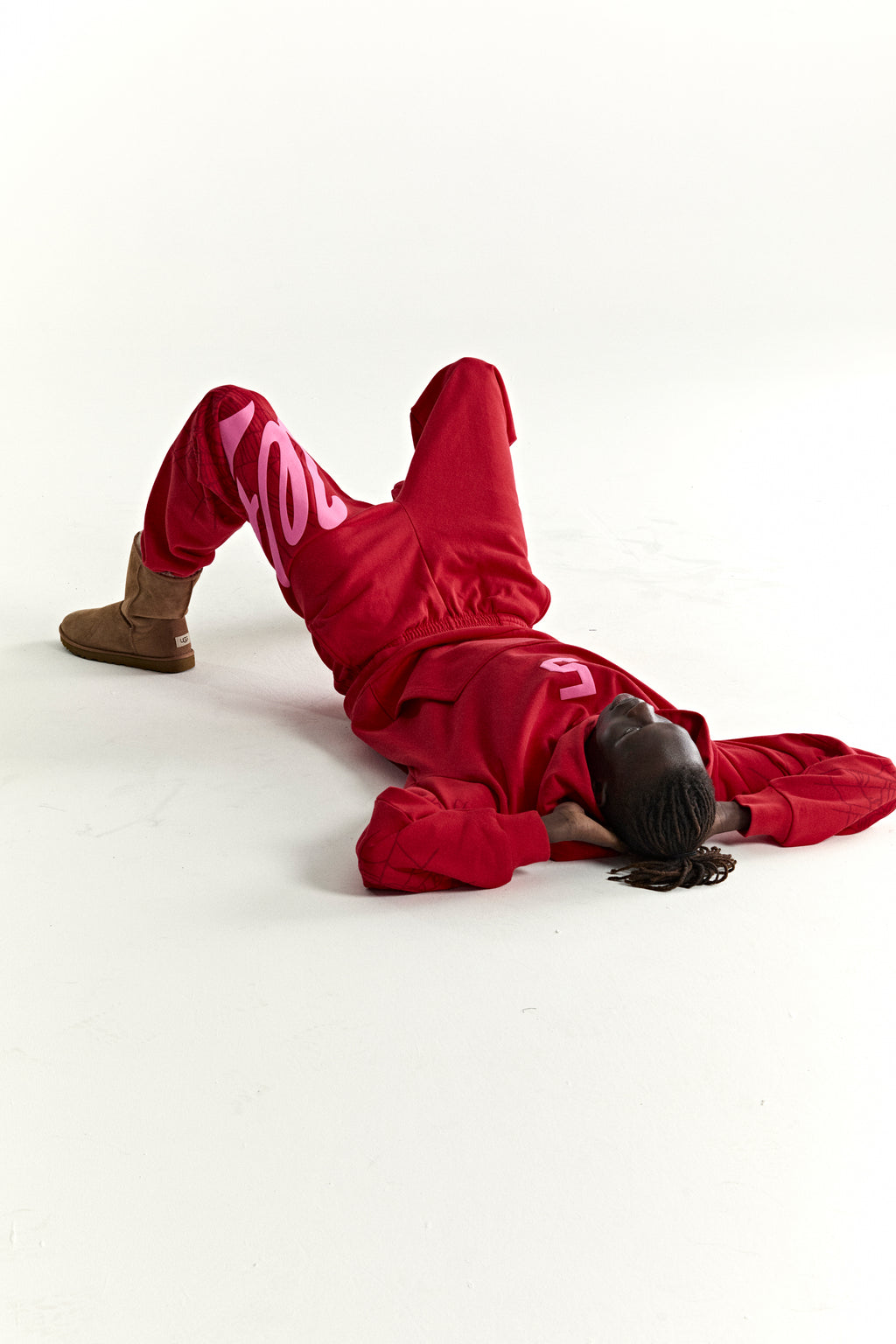 Red 13oz cotton fleece STADIUM HOODIE and sweatpants with pink puff print, web detail, and kangaroo pocket.