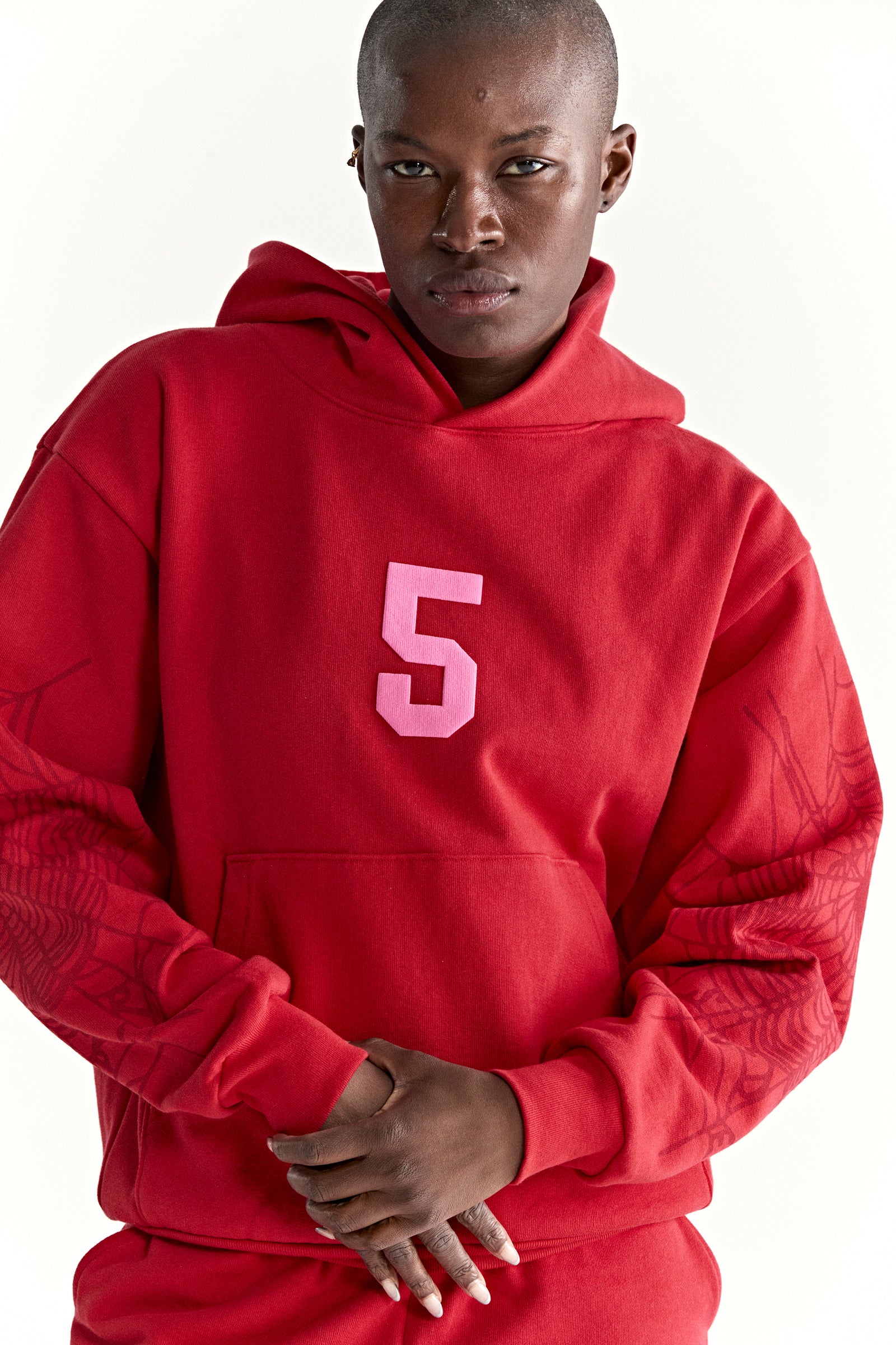 Red 13oz cotton fleece STADIUM HOODIE with pink '5' graphic, web detail sleeves, and kangaroo pocket.
