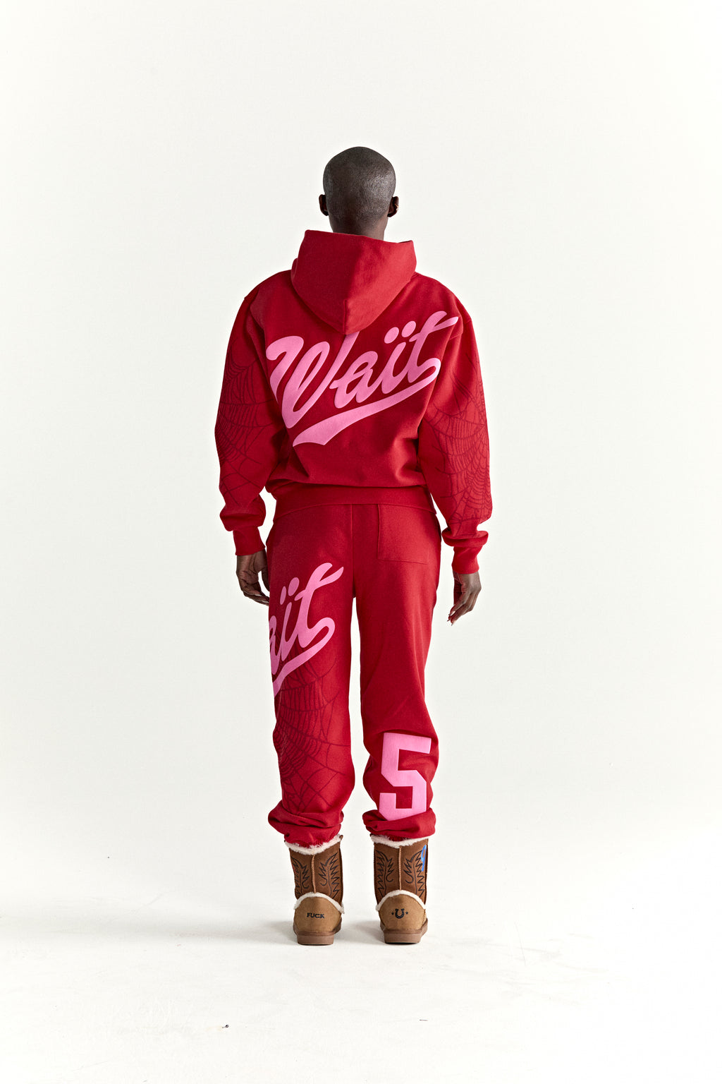 Red 13oz cotton fleece hoodie and sweatpants with pink "Wait" script, "5" graphic, and web detail.