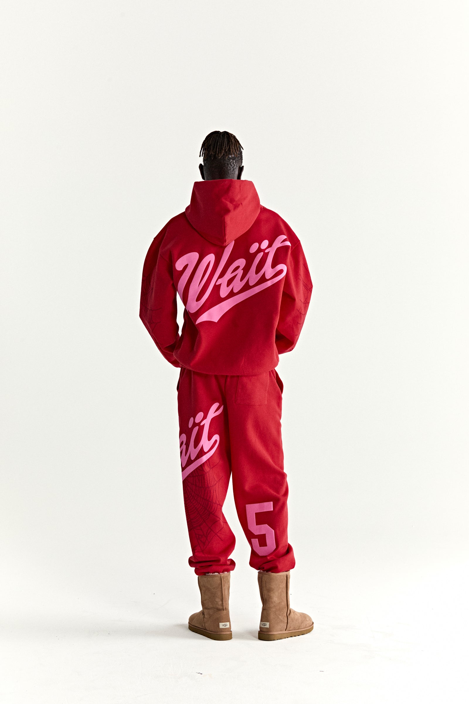 Red 13oz cotton fleece hoodie and sweatpants with pink "Wait" script, "5" graphic, and web detail.