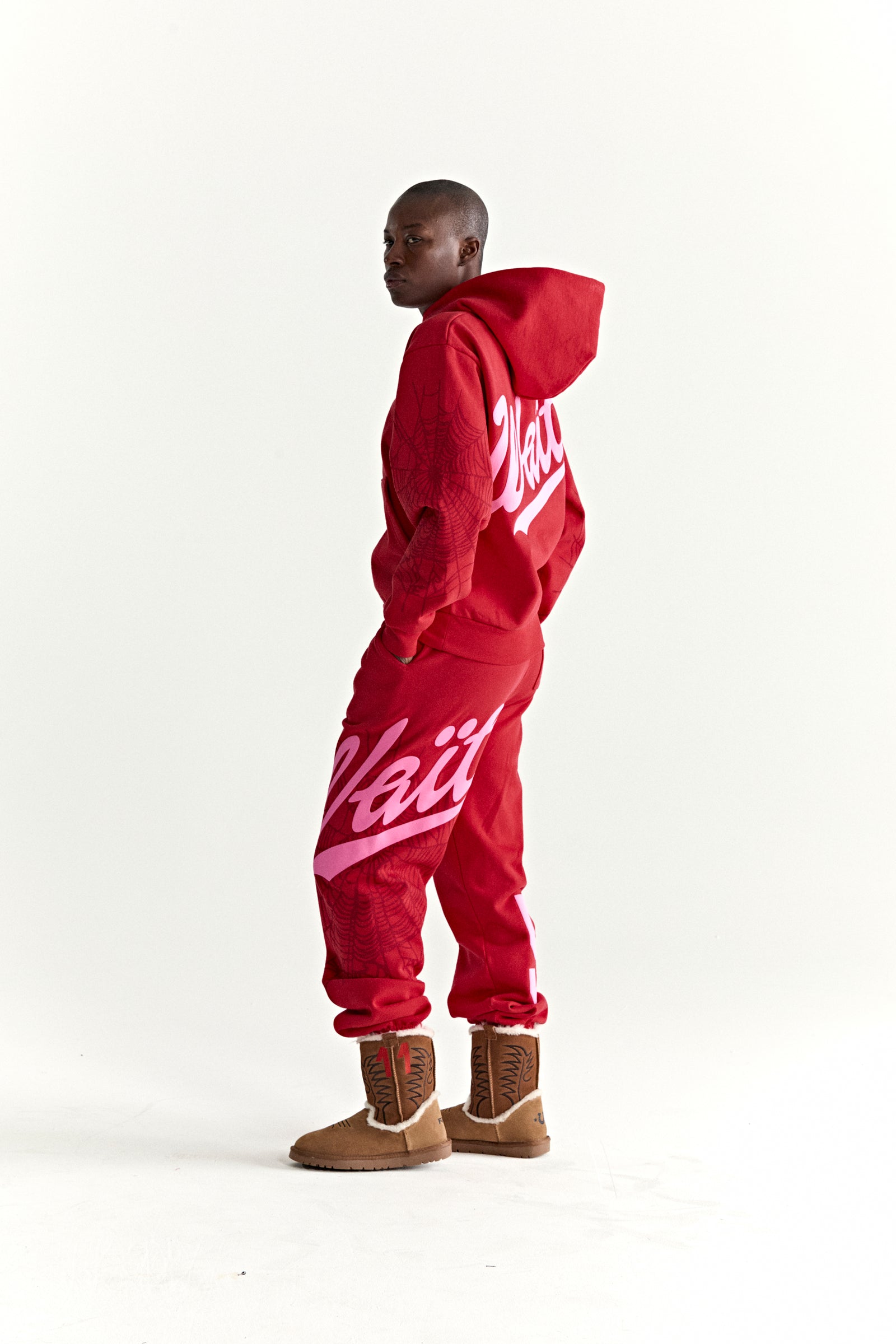 Red 13oz cotton fleece hoodie and sweatpants with pink puff print 'Wait' text and web detail.