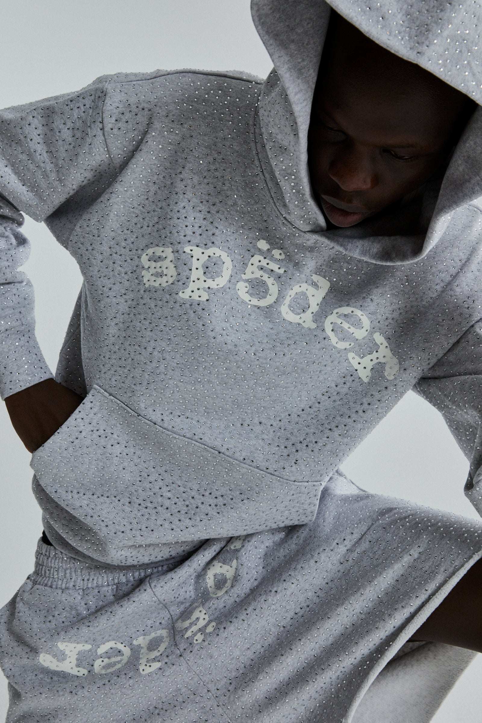 Gray VVS HOODIE with all-over tonal rhinestones and "SP5DER" chest print, worn by a person.
