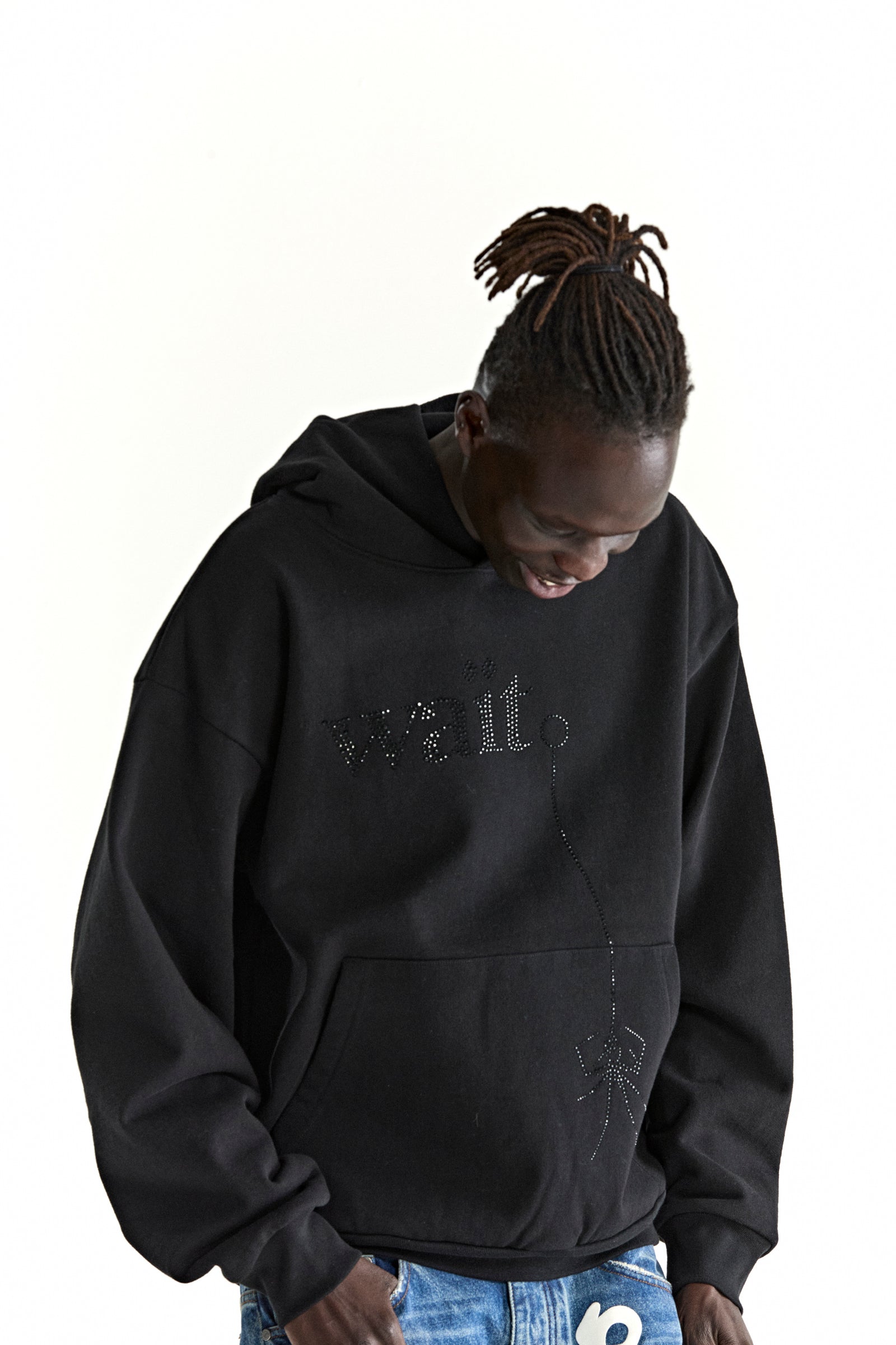 Black cotton fleece hoodie with rhinestone 'Wait' detail and spider design, worn by a person with dreadlocks.