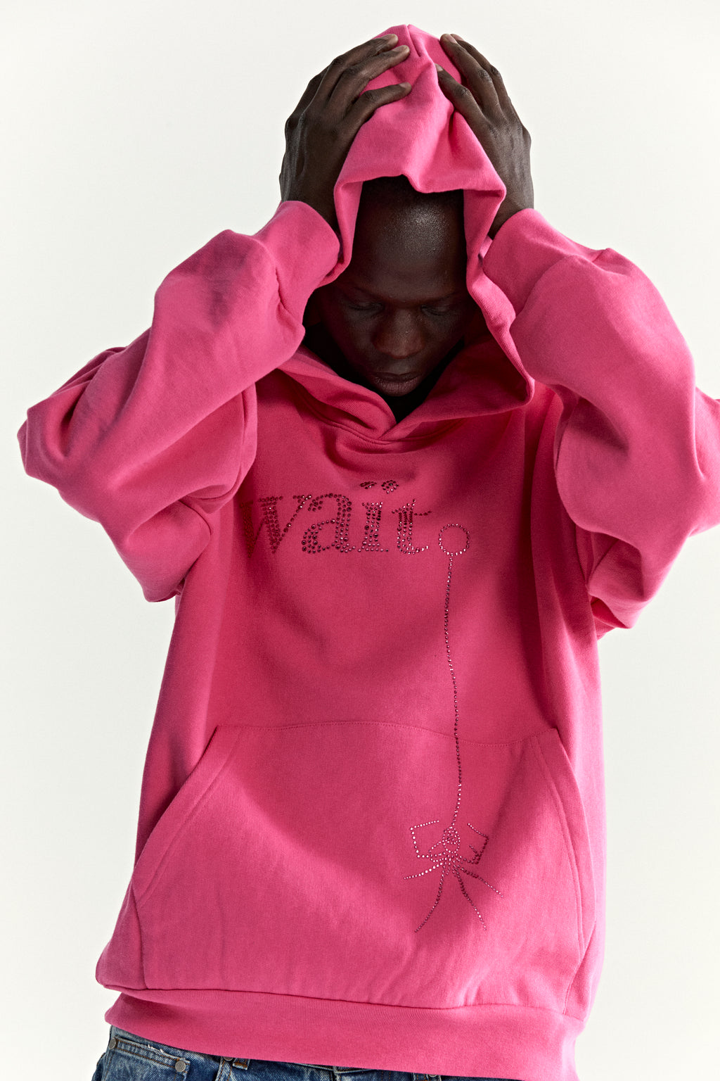 Pink cotton fleece hoodie with rhinestone "Wait" detail, kangaroo pocket, and rib knit cuffs.