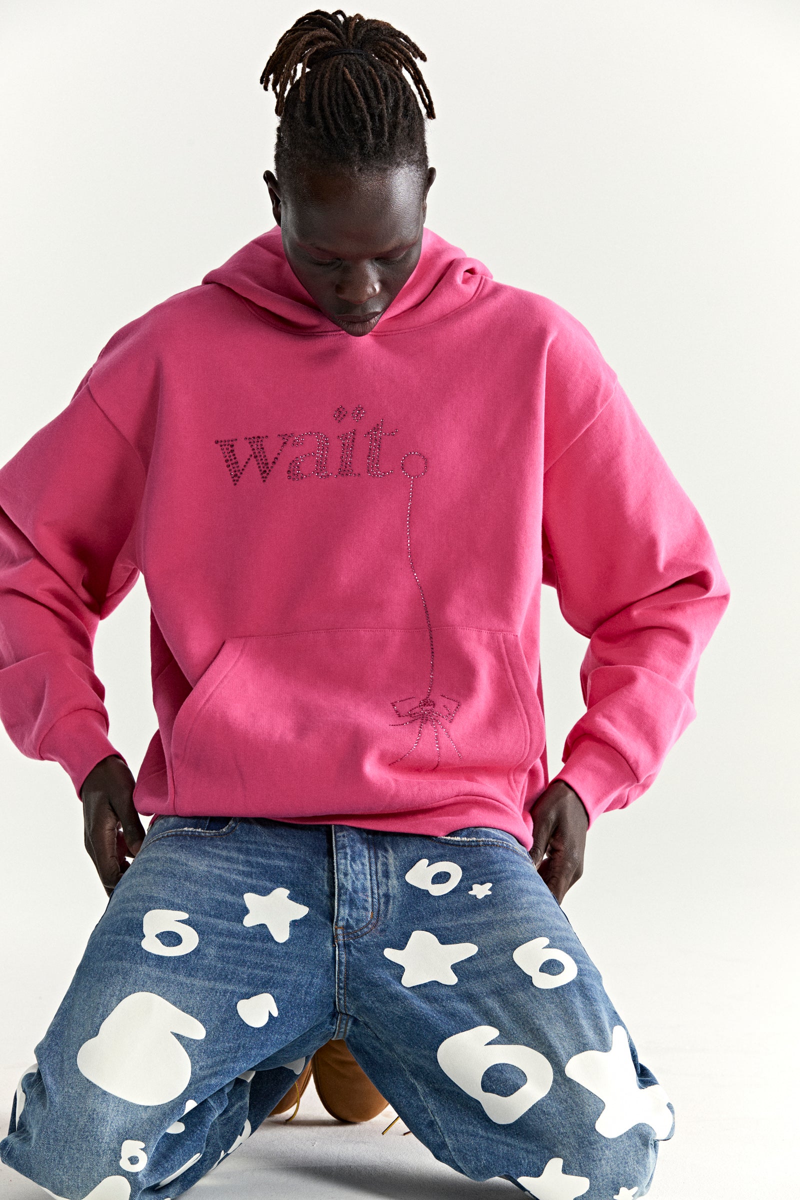 Pink cotton fleece hoodie with rhinestone "Wait" detail and kangaroo pocket.