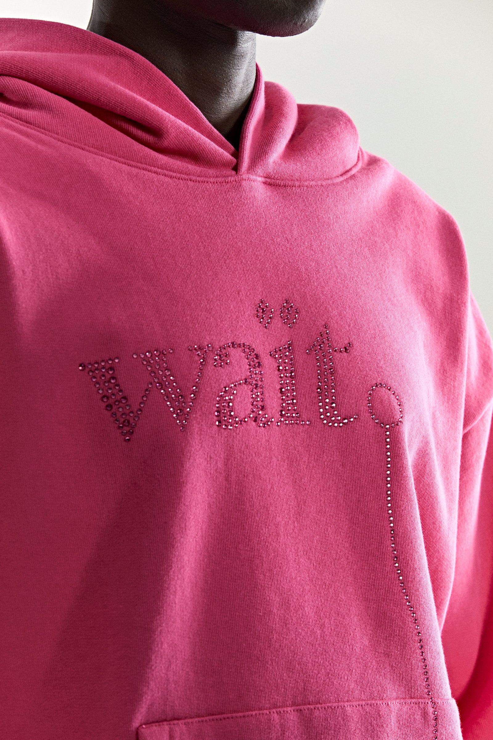 Pink 13oz cotton fleece hoodie with rhinestone "Wait" detail and kangaroo pocket.