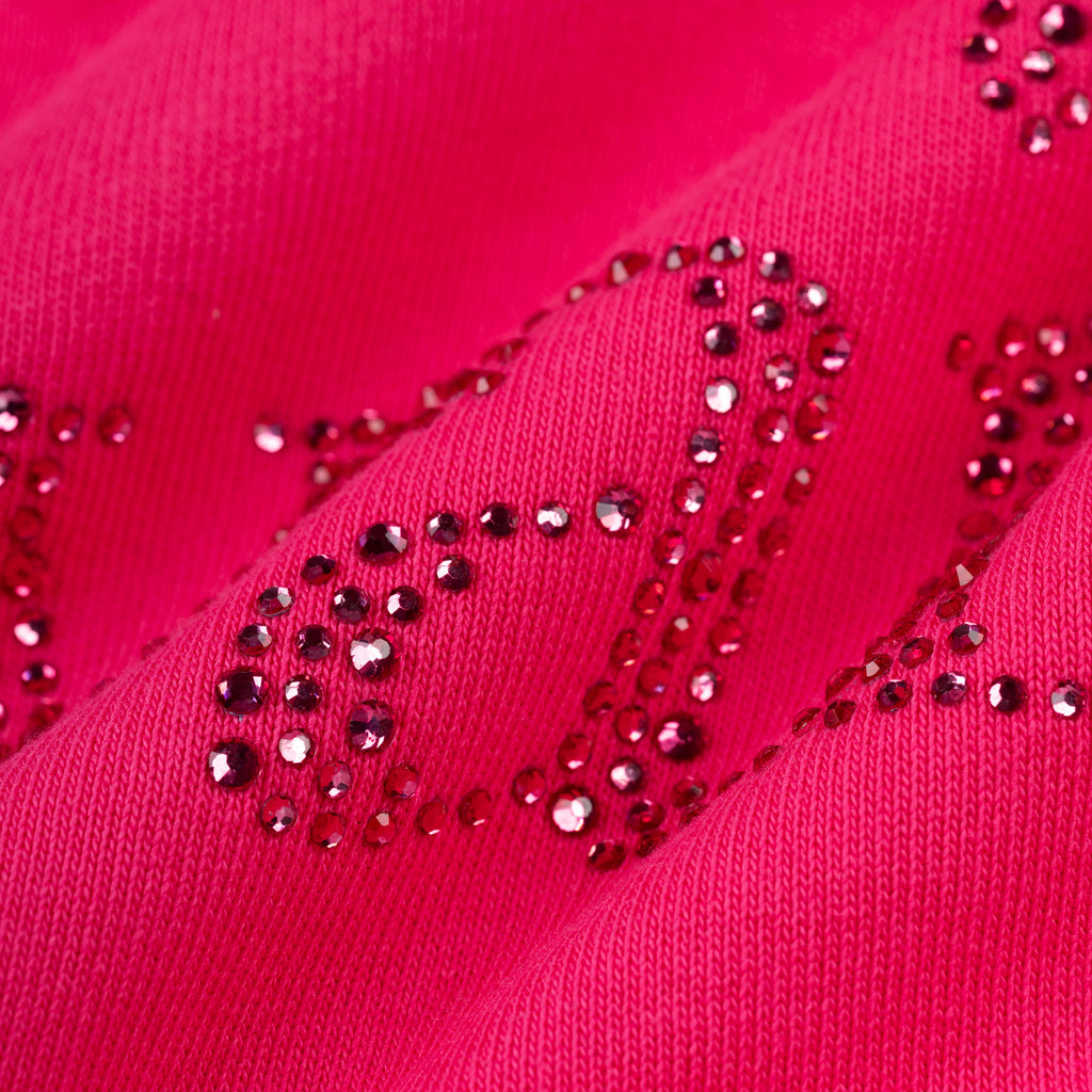 Close-up of a vibrant pink cotton fleece hoodie with "Wait" spelled out in sparkling pink rhinestones.