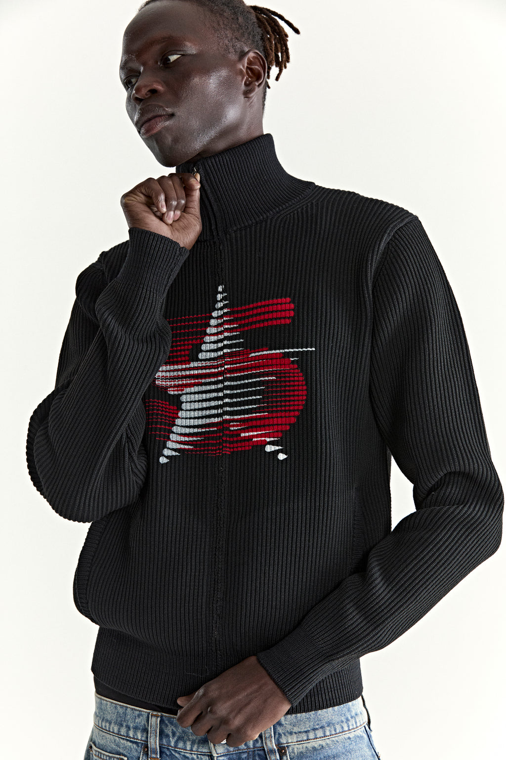 Black ribbed wool/cotton zip sweater with stand collar and red/white graphic.