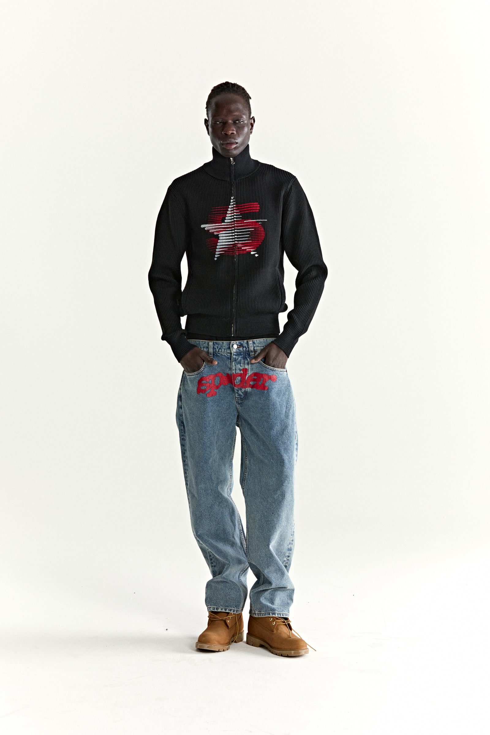Black ribbed wool/cotton zip sweater with a red and white 5-star graphic, worn by a model.